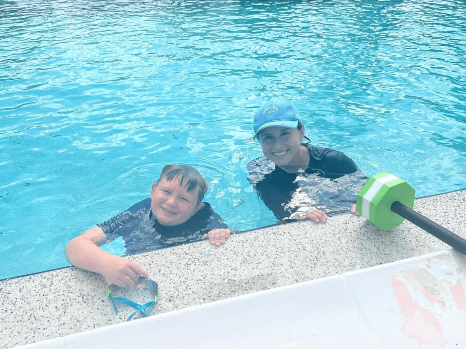 Dr. Amanda Clarke at the pool wall with a young student