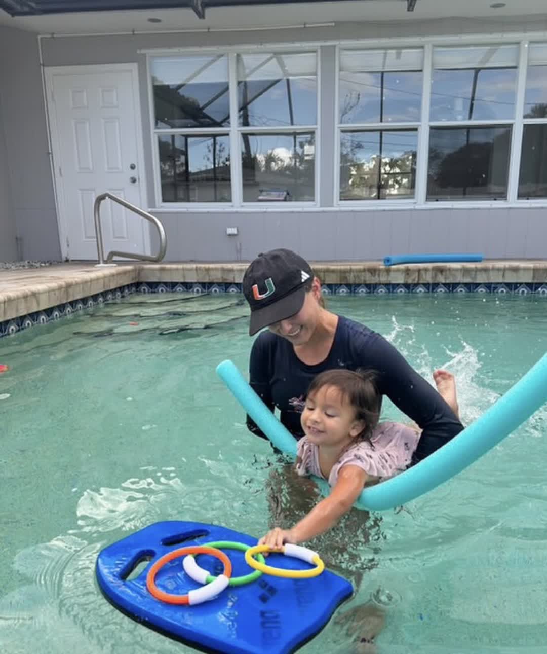 Dr. Amanda Clarke guiding a toddler with a kickboard
